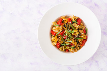 Stir Fry from chicken fillet, green beans and paprika with pasta in the form of heart. Flat lay. Top view
