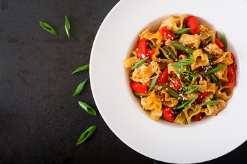 Stir Fry from chicken fillet, green beans and paprika with pasta in the form of heart. Flat lay. Top view