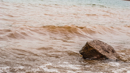 Muddy Waves Hitting a Rock