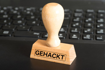 Ein Computer und ein Stempel mit dem Aufdruck Gehackt