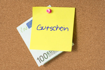 Euro Geldschein und ein Gutschein an einer Pinnwand