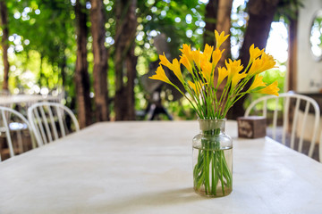 Yellow flowers in a glass vase on a table