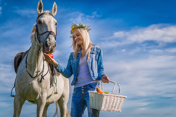 the girl feeds a horse in the field