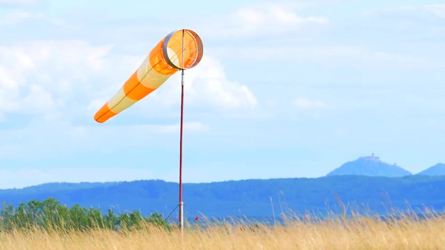 Wind sock fly. Summer hot day on privat sporty airport with abandoned windsock, wind is blowing and windsock is lazy  moving