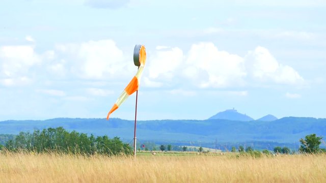 Wind sock fly. Summer hot day on privat sporty airport with abandoned windsock, wind is blowing and windsock is lazy  moving
