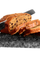 Fruit cake being sliced on a granite chopping board