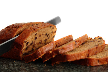 Fruit cake being sliced on a granite chopping board