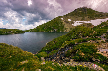 Fototapeta na wymiar lake in mountains with snow on hillside