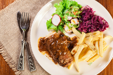 Pork roulade with french fries with salad