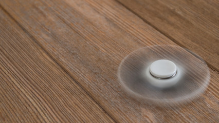 Fototapeta na wymiar Fidget spinner swirling on wooden table
