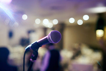 Microphone in concert hall or conference room with defocused bokeh lights in background. Extremely shallow dof. : Vintage style and filtered process