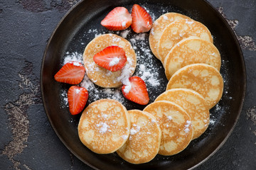 Fritters served with strawberry and powdered sugar in a metal plate, flat-lay, horizontal shot