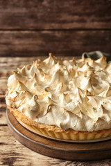 Fototapeta premium Board with tasty lemon meringue pie on wooden table, closeup