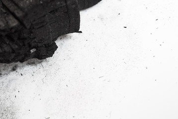 Black abstract textured composition on a white background, a selected focus close-up of a pile of cubes and powder of black mineral coal.