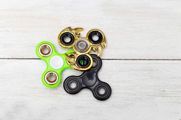 trendy fidget spinners on White wooden background