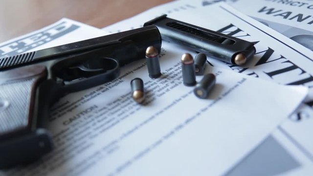 An announcement about the search for a criminal on the table of the bounty hunter, a combat pistol, cartridges