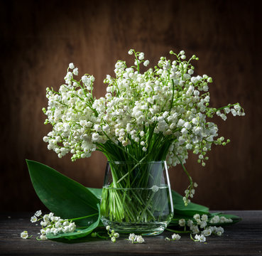 Lily of the valley bouquet on the wooden table.