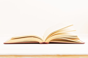 Open old books on a light beige background. Copyspace. Shallow focus.