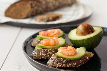 Three open sandwiches with shrimp and avocado