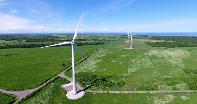 Onshore wind farm with group of horizontal axis wind turbines is in grassland near Gulf of Finland, Estonia. Aerial view