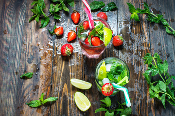 set with mojito lime and strawberry cocktails on wooden background