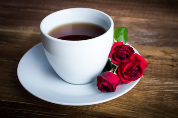 Coffee and roses on a wooden background