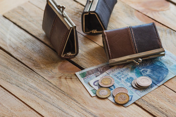 Polish zloty with a little wallet on the old wooden background