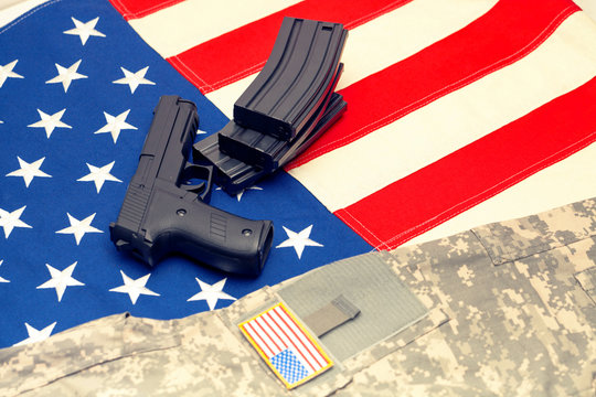 Handgun and US army uniform over USA flag