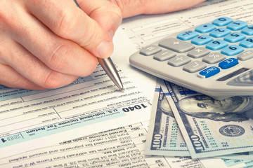 Male filling out 1040 United States of America Tax Form