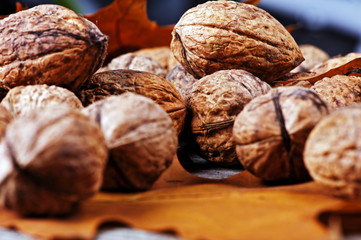 Walnuts amidst autumn leaves on a wooden table