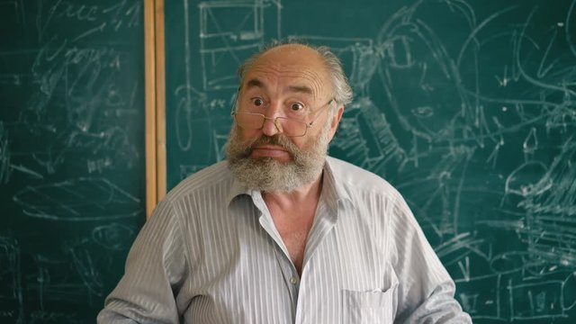 A charismatic old teacher explaining and shouting near the blackboard 4K