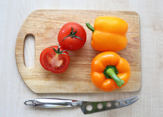 orange bell pepper, tomato on Board
