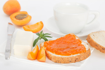Apricot jam, butter and milk for breakfast. Sweet food.