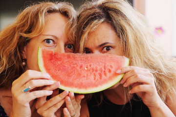 Portrait of two 40 years old woman eating watermelon