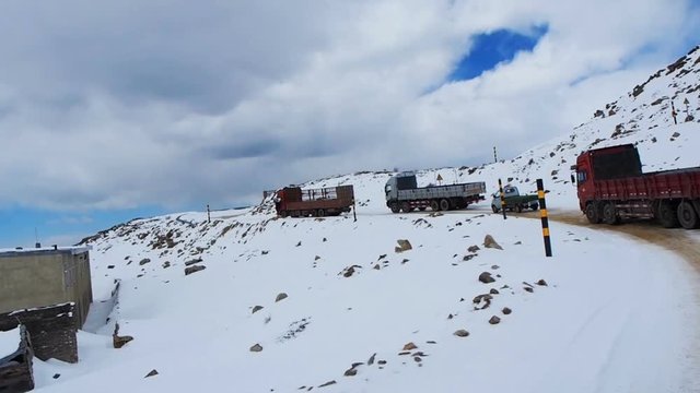 Line of trucks waiting to pass the slippery and narrow street at Trola Pass in SiChuan, China