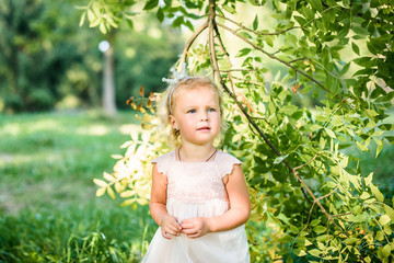 Portrait of a Cute smiling little girl in green park