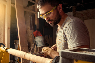 builder handles the  wooden on a lathe