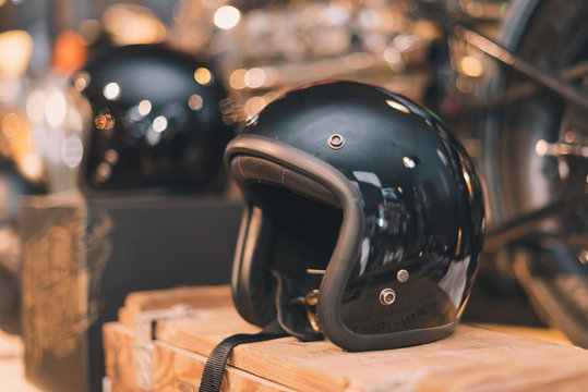 Black glossy vintage helmet place on the wooden box in selective focus with vintage tone.