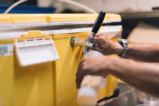 Close Up Of Hands Are Pressing The Beer Out Of The Faucet At Cold Storage.