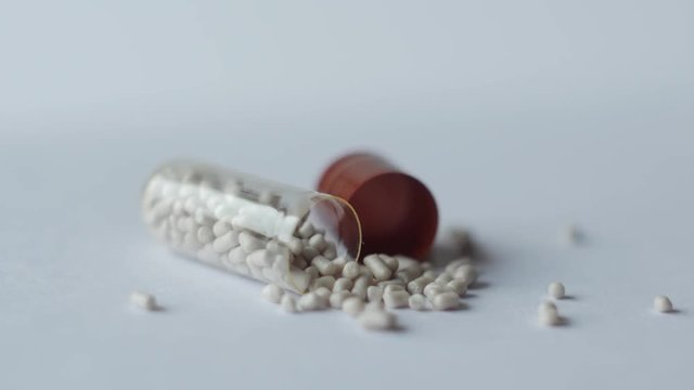 disassembled digestive enzyme capsule rotates on a white background