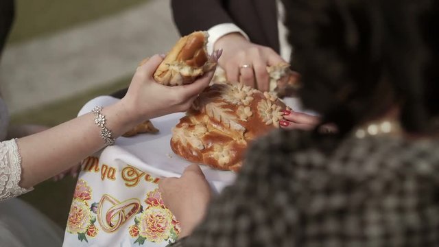 Bride and groom breaking traditional wedding bread and salt