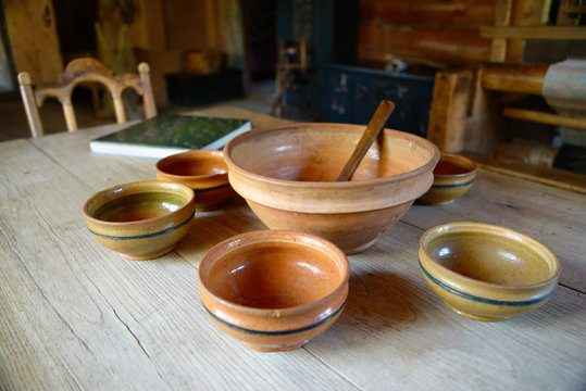 wooden and clay dinnerware on and old wooden table
