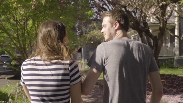 Cute Couple Walk (Away From Camera) Around City Neighborhood, Man Twirls His Girlfriend (Slow Motion)
