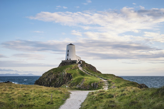 Stunning Summer landscape image of lighthouse on end of headland with beautiful sky