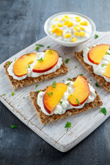 Homemade Crispbread toast with Cottage Cheese and nectarine on white wooden board.