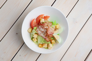Top view of salad with grilled bacon, crackers, egg, tomato and cheese