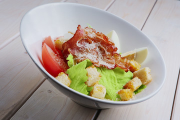 Salad with grilled bacon, crackers, egg, tomato and cheese