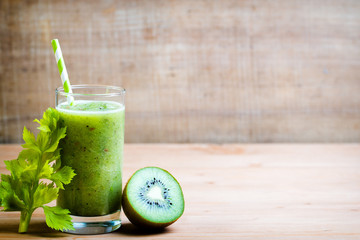 Healthy green smoothie in a glass on old wood.