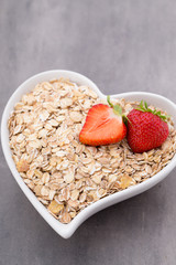 Dry rolled oatmeal in bowl.