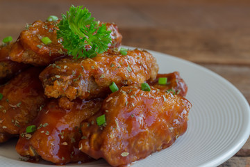 Barbecue chicken wings on white plate served with barbecue dipping sauce. Homemade bbq chicken wing delicious,moist and spicy. Barbecue chicken wing served with chili sauce or tomato sauce(ketchup).